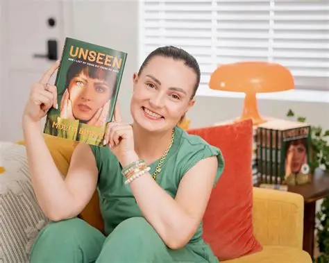 Molly Burke holding her book UNSEEN