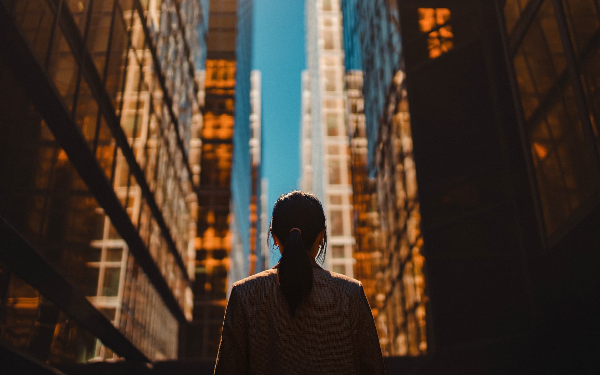 A woman looking up at towering city buildings