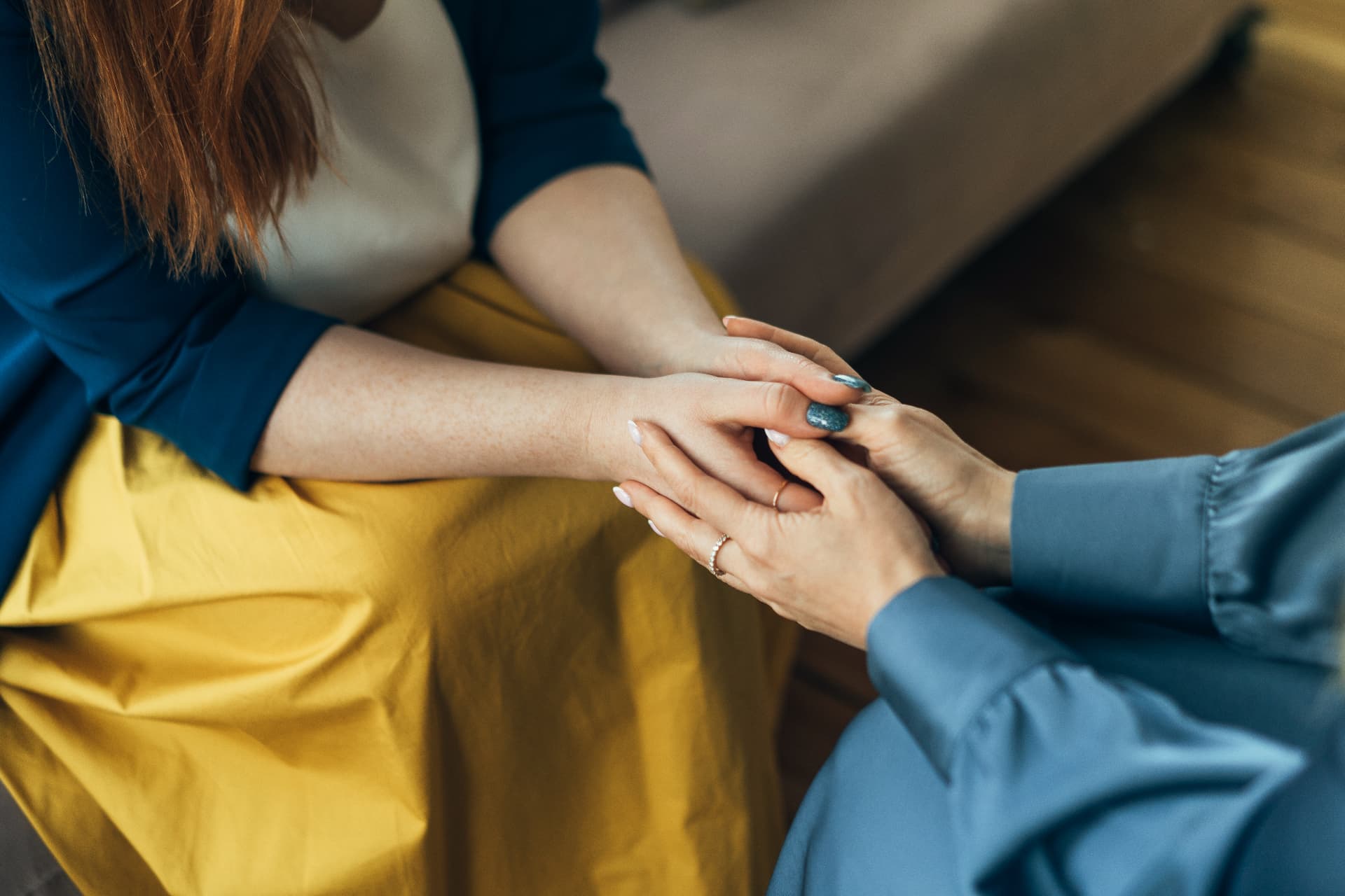 Two people holding hands in comfort and support